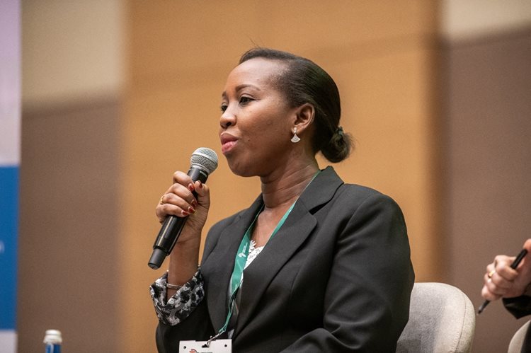 Woman speaks into microphone on a panel